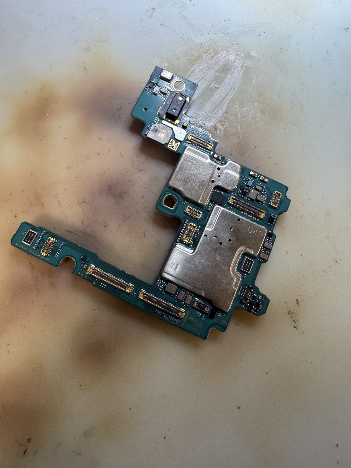 お預かり時のGalaxy S23 Ultraの基板全体。水シミと変色が広範囲に見られる