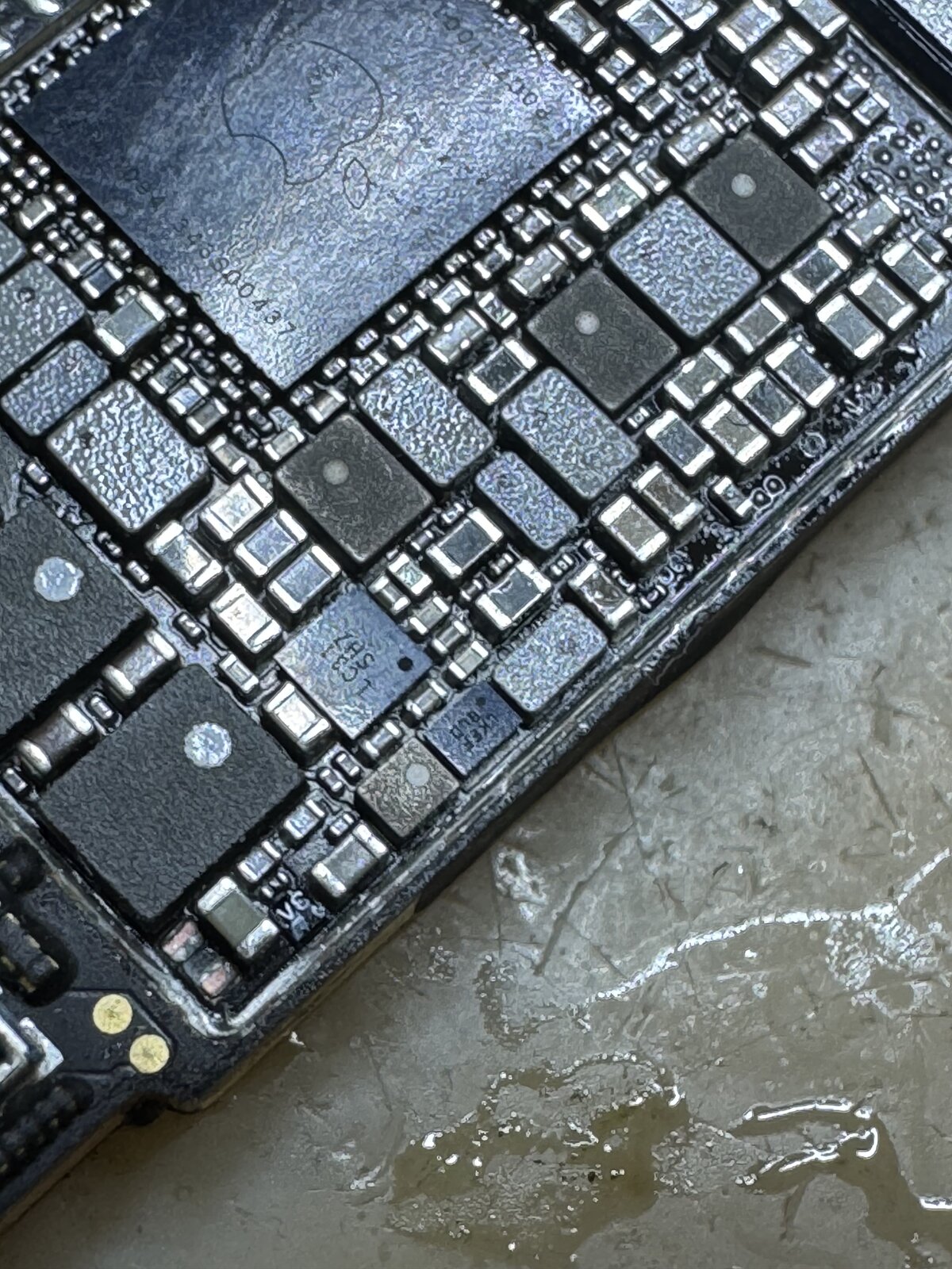 iPhone 12の基板を顕微鏡で拡大した写真。タッチ回路周辺のコイルやICが並んでいる