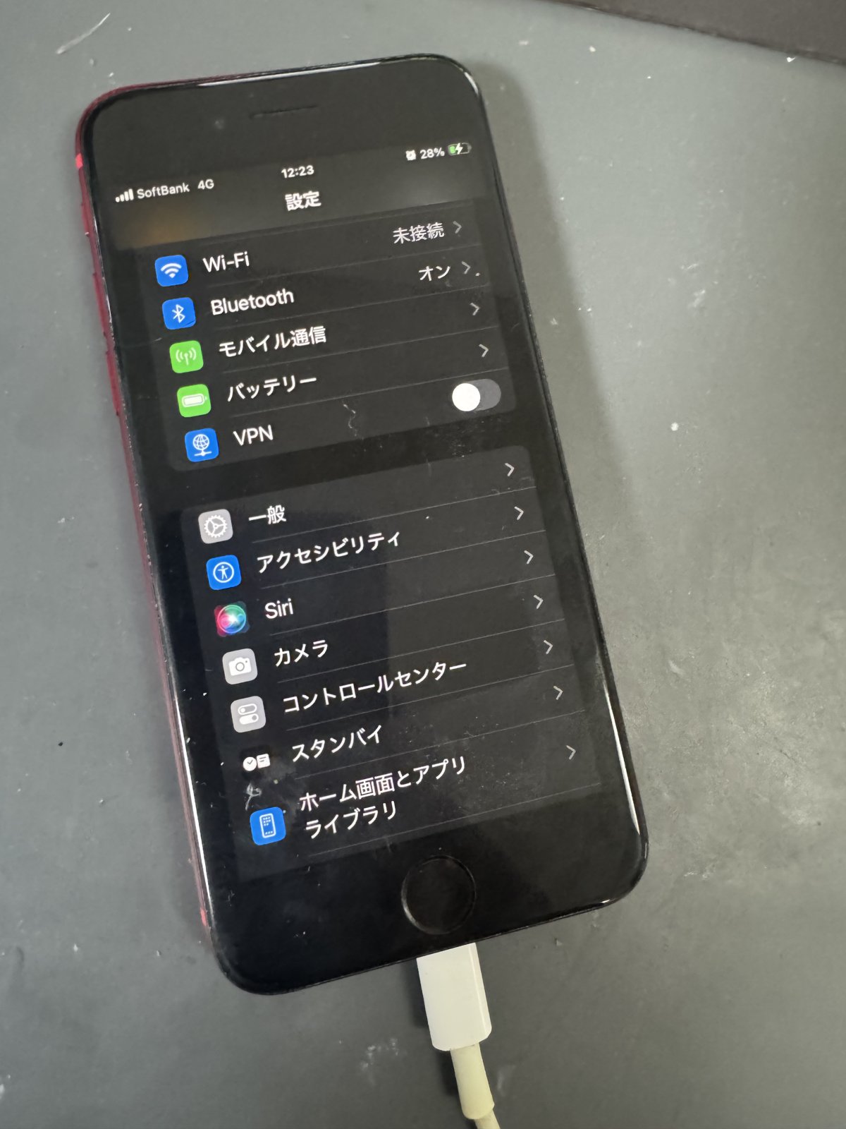 修理後に起動し設定画面を表示して充電中のiPhone SE(第2世代)